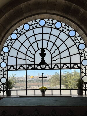 Blick auf Jerusalem durch das Fenster einer Kirche mit Kreuz