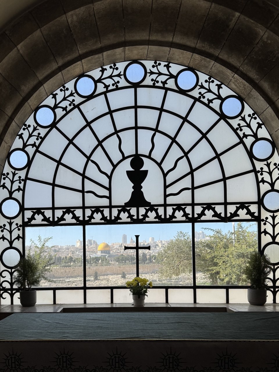 Blick auf Jerusalem durch das Fenster einer Kirche mit Kreuz